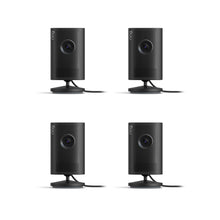 Plug-In / Black/ 4-pack:Indoor Cam 2K. Four black, cylindrical Indoor Cam 2K. Four devices are standing on a small circular base.