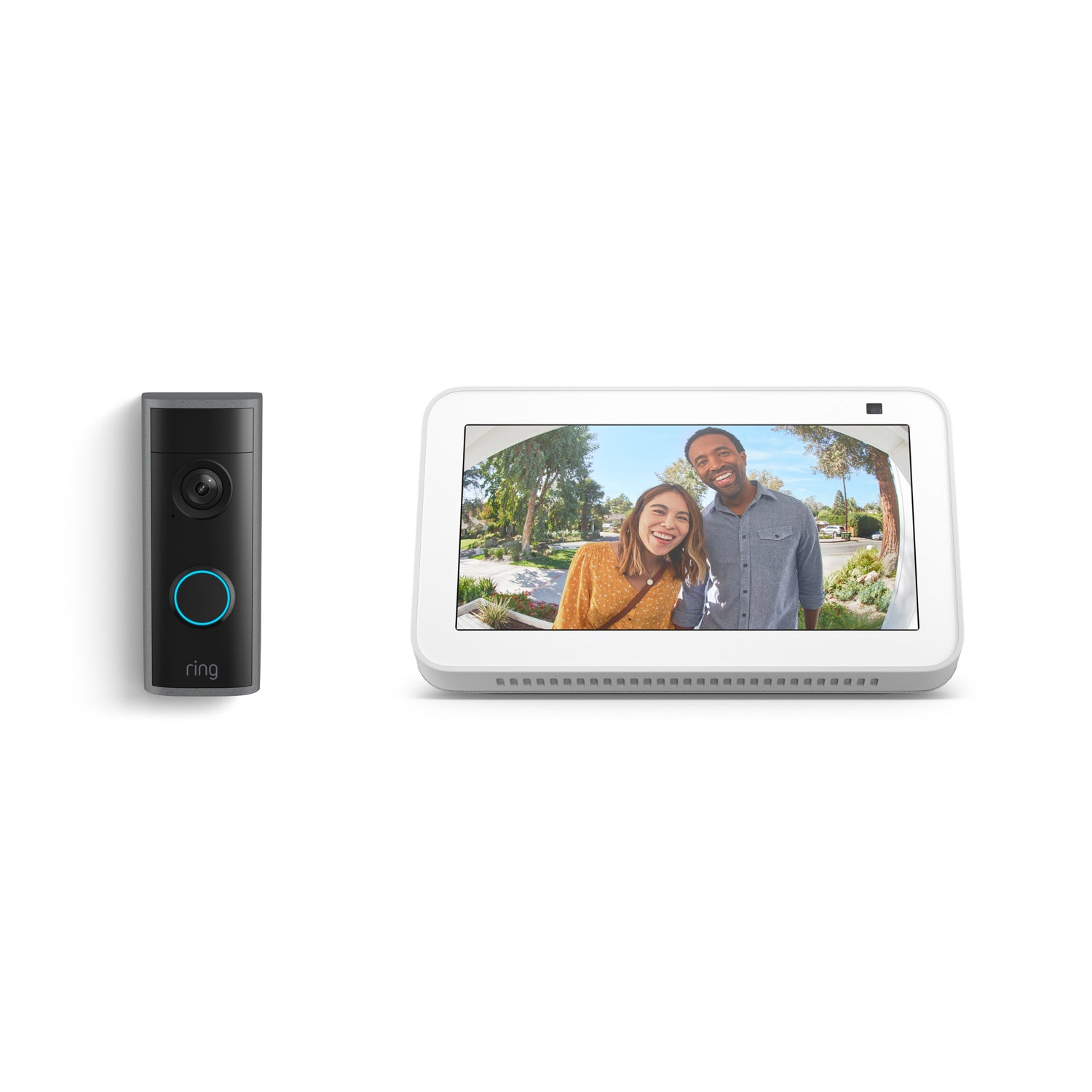 Black Ring doorbell next to a white smart display showing a wide-angle view of two smiling visitors at a front door.