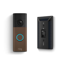 Battery Doorbell 2K with bronze faceplate and blue-lit button beside a black solar panel mount showing rear charging port.