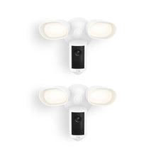 Two white Ring floodlight cams with dual LED lamps and central camera units, shown front-facing on a plain white background.