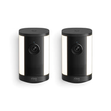 Pair of black Ring outdoor cameras with cylindrical design, front lenses, LED status lights, and side light panels on a white background.
