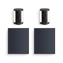 Two black Ring spotlight cameras with lights, paired with two rectangular black solar panels on a white background.