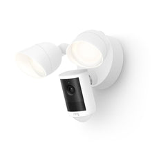 White outdoor floodlight with dual lamps and a built-in Ring camera on a wall, modern design with black lens panel.