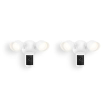 Two white outdoor floodlight camera units with dual adjustable lights and a central camera, shown against a plain white background.