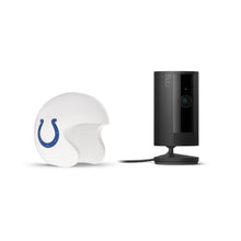 Black Ring indoor camera on a stand next to a white football helmet with a blue horseshoe logo on a white background.