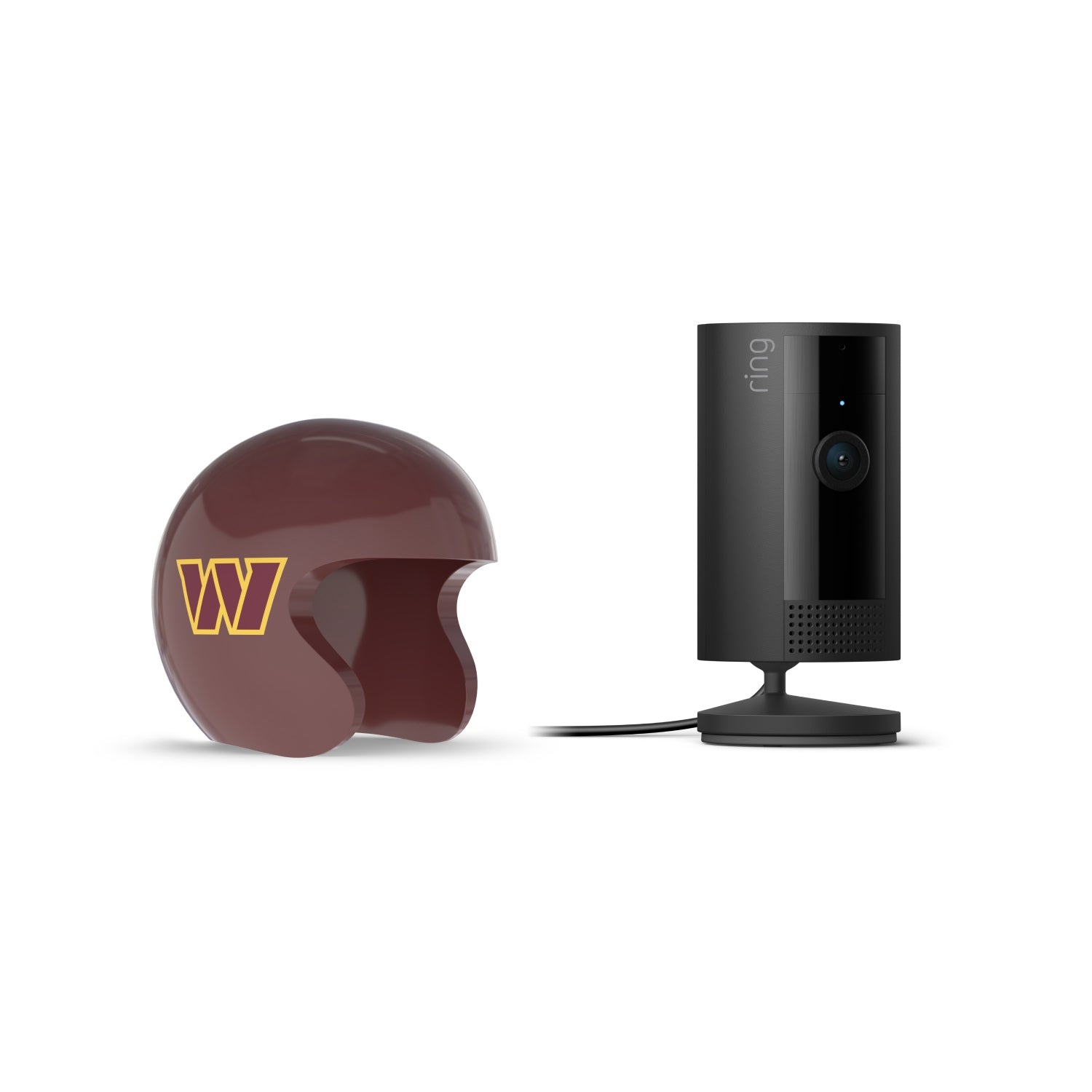Black Ring indoor camera on a stand next to a maroon mini football helmet with a yellow “W” logo on white background.