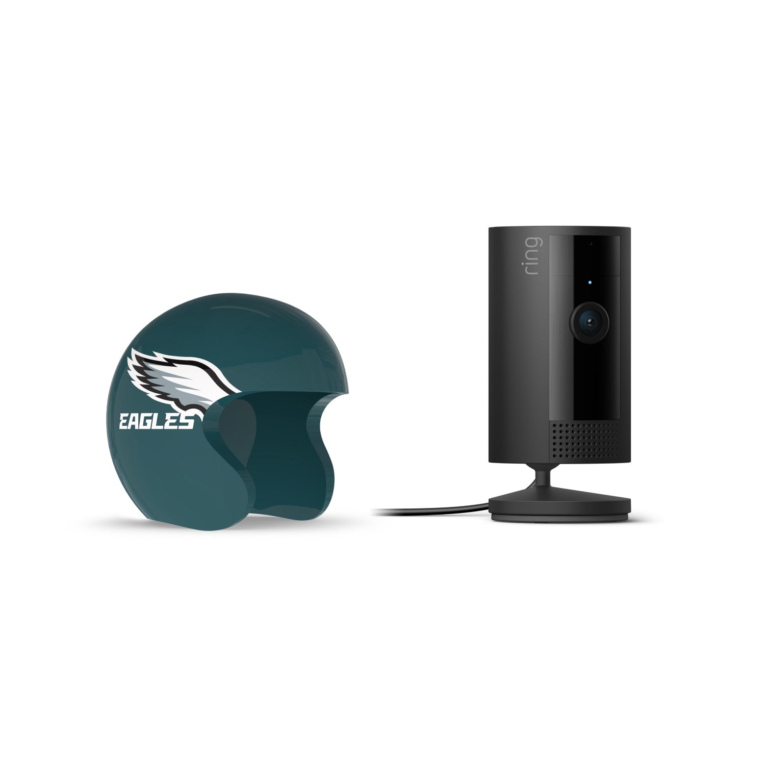 Black Ring indoor camera on a stand next to a teal mini helmet with a white wing logo and “Eagles” text on a white background.