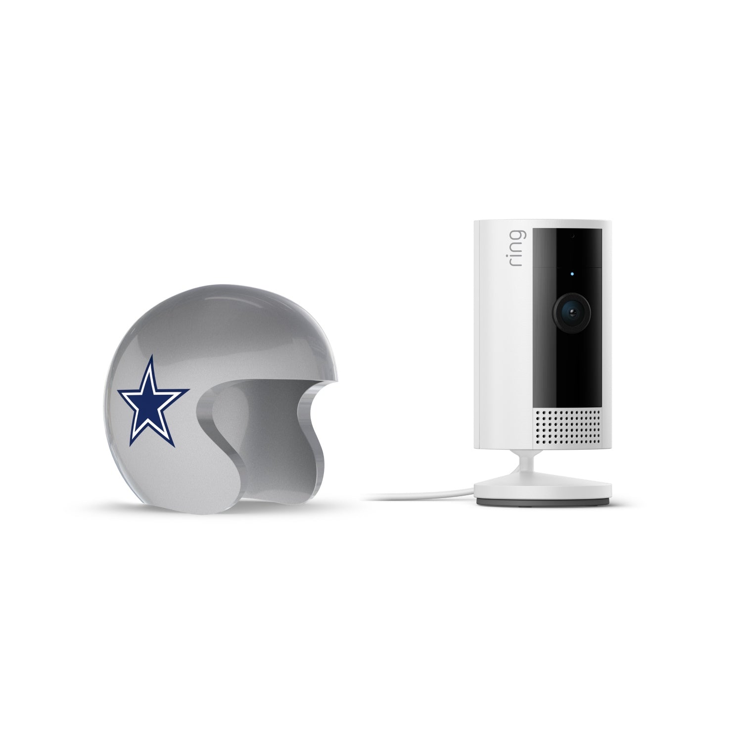 White Ring indoor camera on a stand next to a silver football helmet with a blue star logo, on a white background.