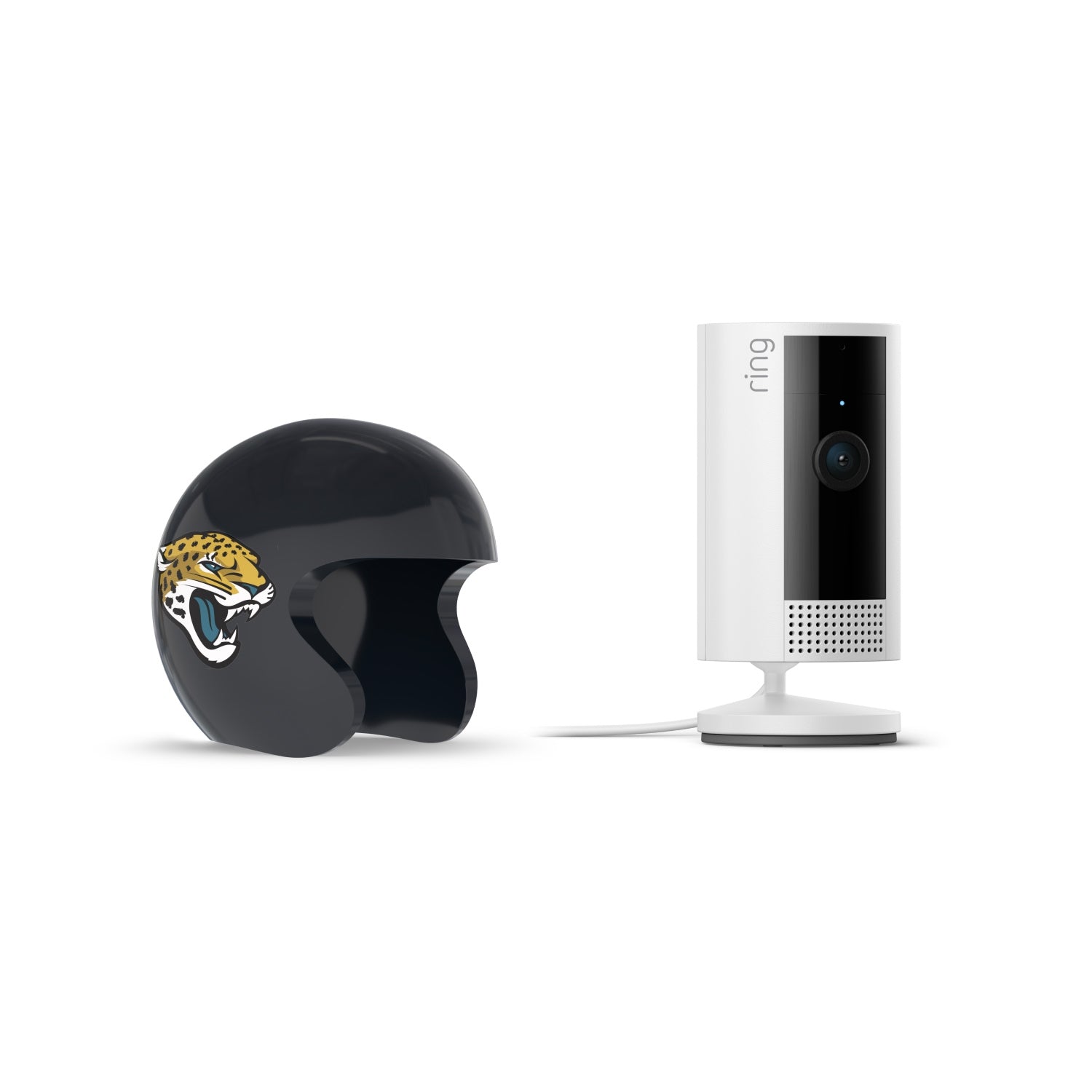 White Ring indoor camera on stand next to a black mini football helmet with a jaguar logo, both on a white background.