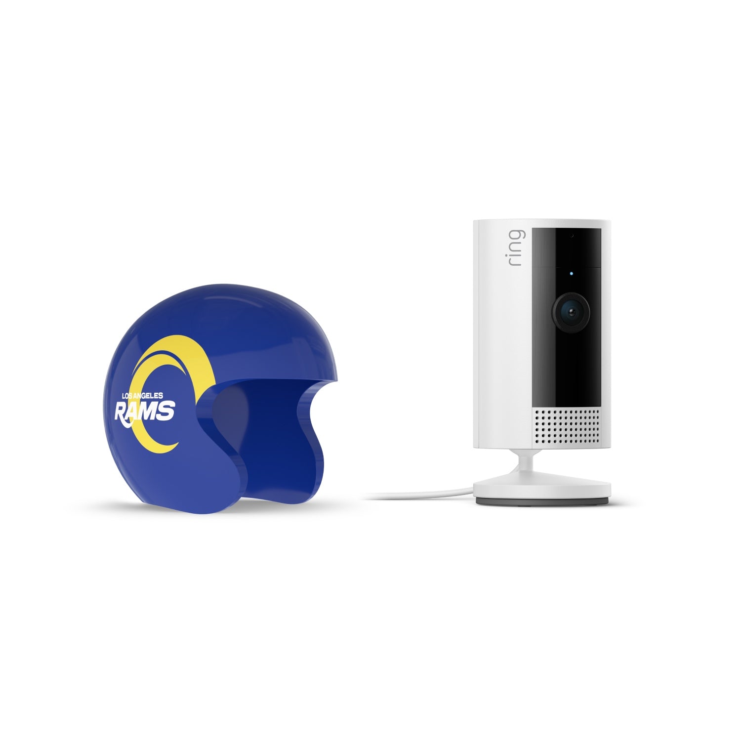 White Ring indoor camera on a stand beside a blue Los Angeles Rams mini helmet with yellow logo, set against a white background.