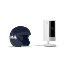 Ring indoor camera beside a navy Seattle Seahawks mini helmet on a white background.