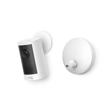 White Ring Outdoor Cam on a wall mount with detachable circular base, showing lens, speaker grille, and side-by-side mounting plates.