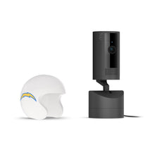 Black Ring indoor camera on a powered stand next to a white mini football helmet with a blue and yellow lightning bolt logo on white background