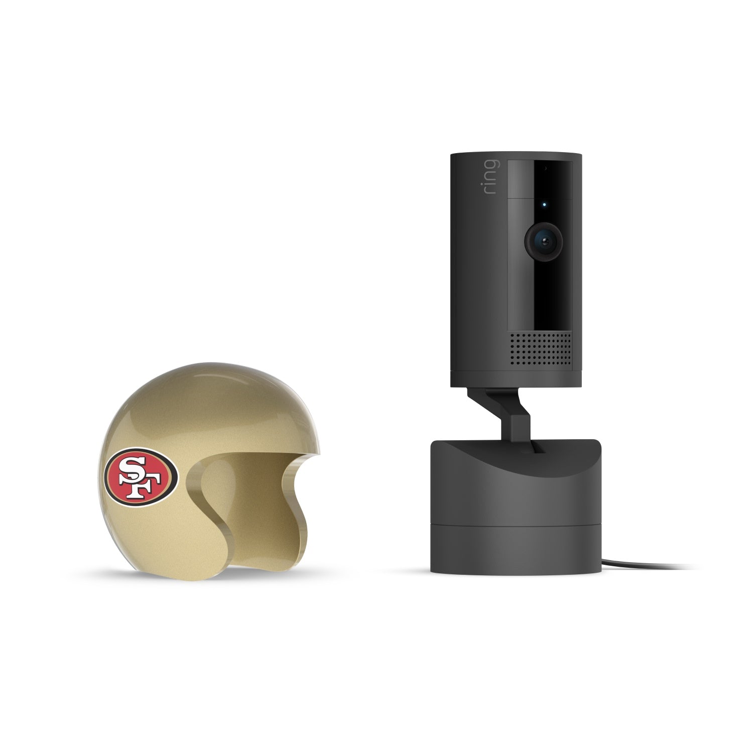 Black Ring indoor camera on a swivel base beside a gold mini helmet with a red SF logo, set against a white background.