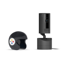 Black Ring pan-tilt indoor camera on a stand beside a glossy black mini helmet with the Pittsburgh Steelers logo, on a white background.