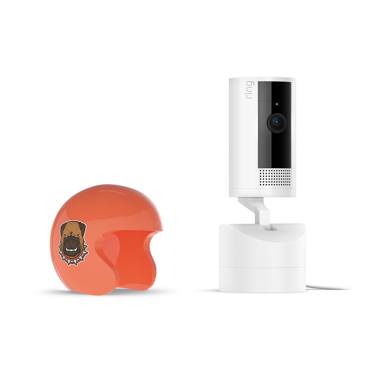 White Ring Pan-Tilt indoor camera on stand beside glossy orange open-face helmet with a fierce dog decal, on a white background.