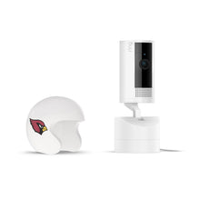 White indoor camera on a stand next to a small white helmet shell with a red bird logo, set on a plain white background.