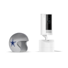White Ring Stick Up Cam next to a small silver football helmet with a blue star logo, on a white background.