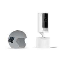White Ring indoor camera on stand beside gray mini football helmet with black-and-blue panther logo on a white background.
