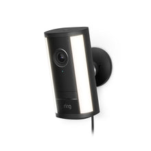 Black wall-mounted Ring security camera with dual vertical LED light strips, lens centered, small status light, and power cable hanging.