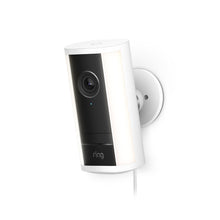 White wall-mounted Spotlight Cam 4K Pro with black face, lens at top, side light panels, speaker grille, and power cord hanging below.
